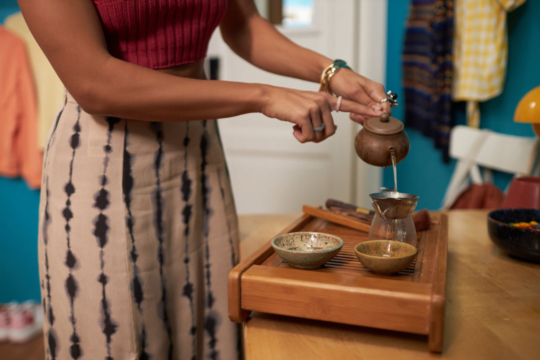 Tee aus Vietnam mit Tradition. Frau gießt Tee ein.