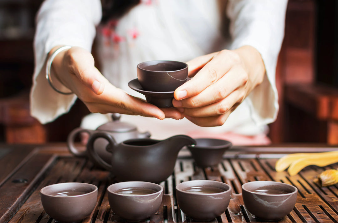 Frau, die chinesischen Tee in einer traditionellen Teezeremonie serviert